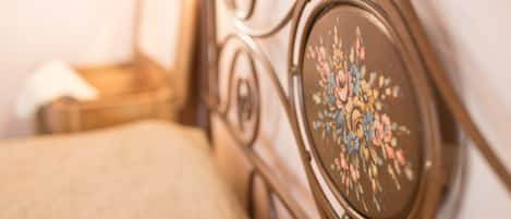 Primer plano de una cama con un cabecero decorado con un diseño floral.