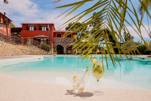 Piscina a l'aire lliure de temporada, para-sols i gandules 
