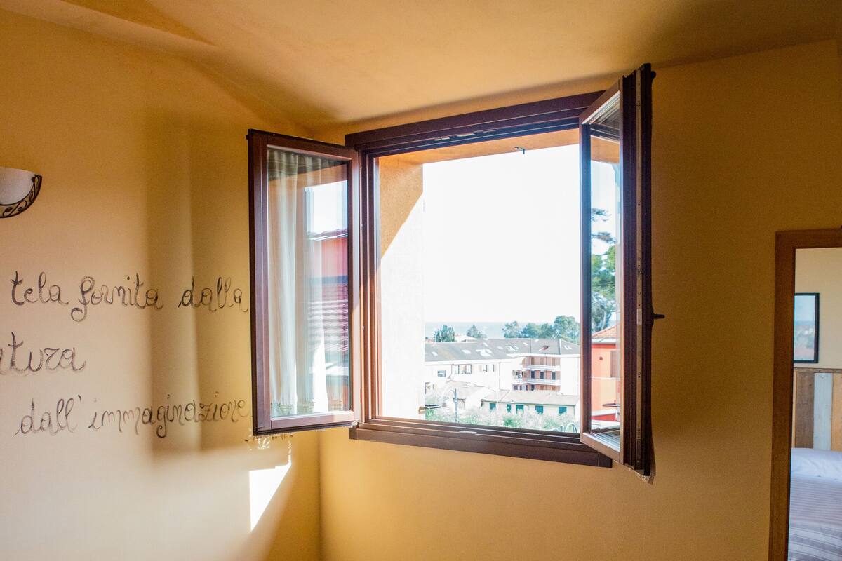 Un dormitorio con una cama, una ventana y una pared con una cita.