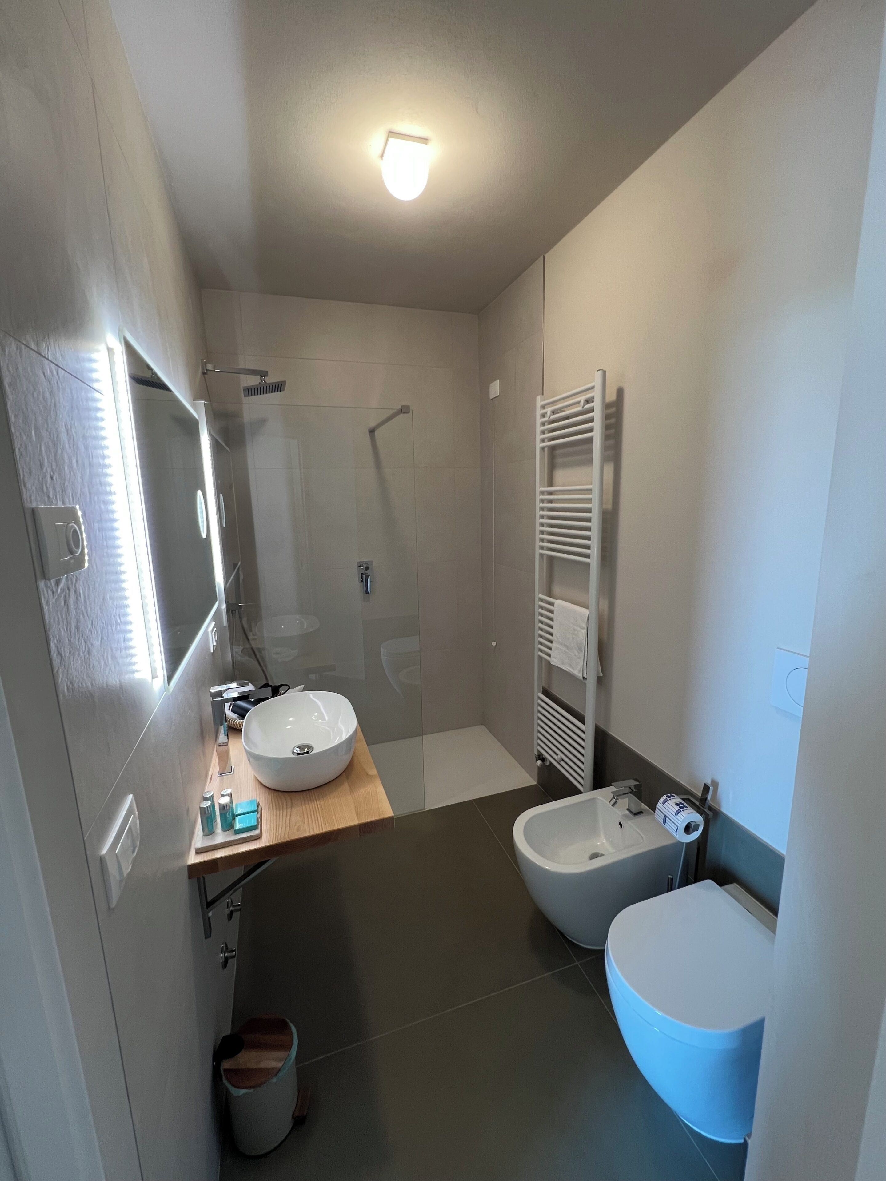 A modern bathroom with two sinks, a shower, and a toilet.