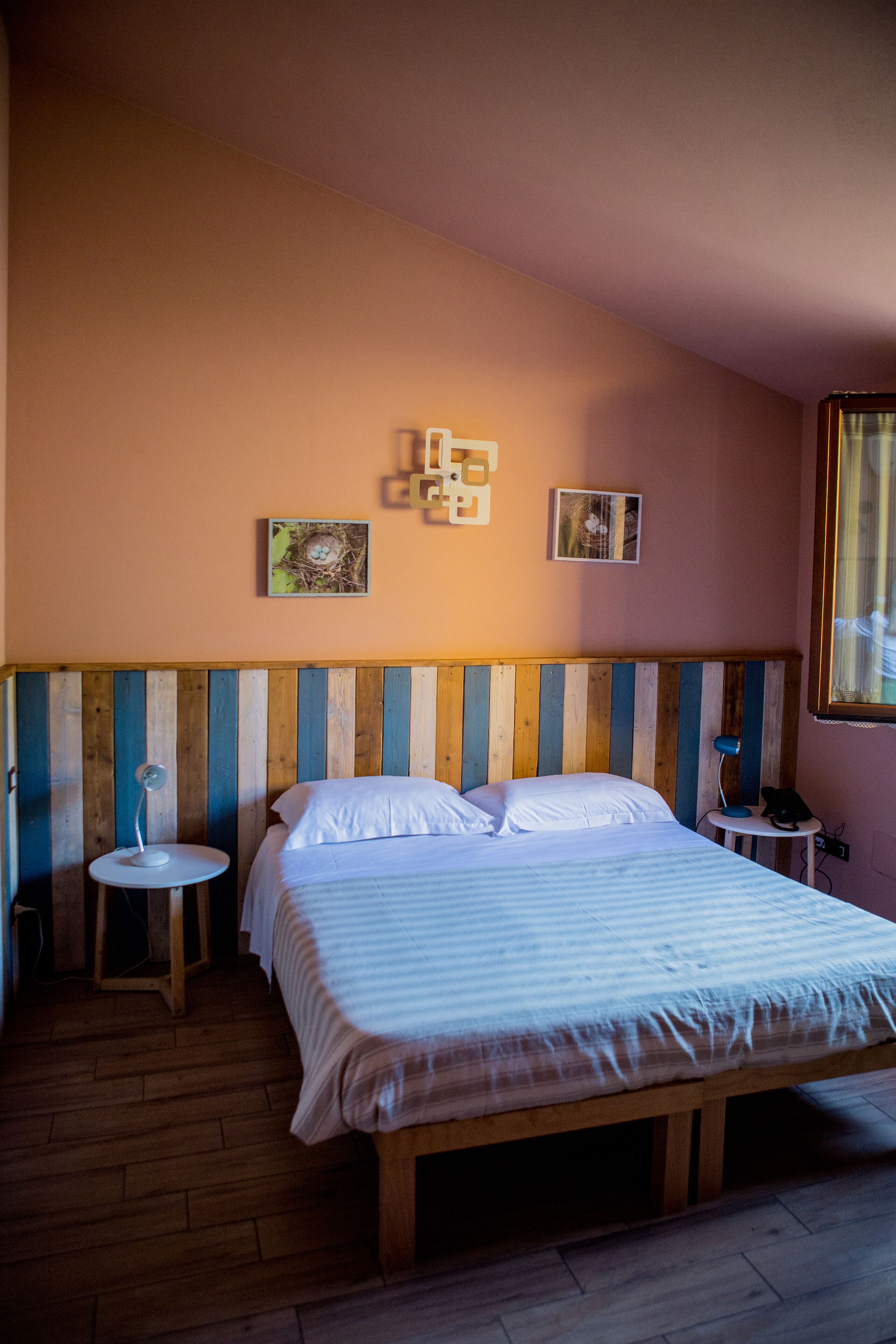 A bedroom with a wooden bed, two bedside tables, and a sloped ceiling.
