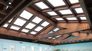 An indoor swimming pool with skylights, tiled walls, and a tiled floor. - Hotel Abbazia (Grado)
