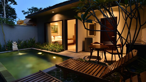 A modern house with a swimming pool, wooden deck, and a dining area with chairs and a table. - Ubud Wana Villa (Ubud)