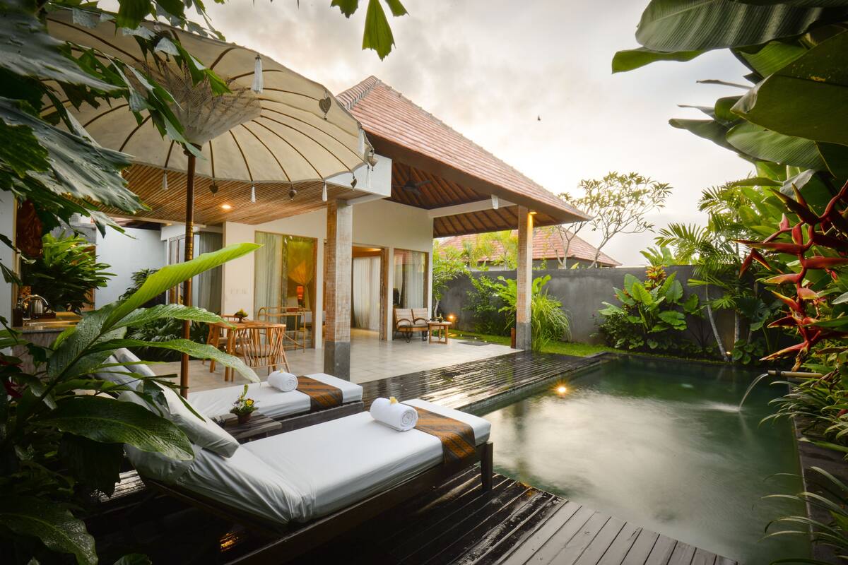 A poolside area with lounge chairs and a covered seating area.