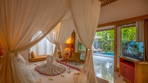 Un dormitorio con cama con dosel, televisión y vistas a una piscina.