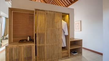 Una habitación moderna de planta abierta con un armario de madera, una pequeña estantería y un cuadro enmarcado en la pared.