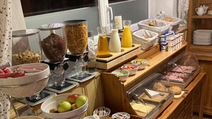 A buffet setup with various food items and condiments. - Pension AdlerHorst (Steindorf am Ossiacher See)