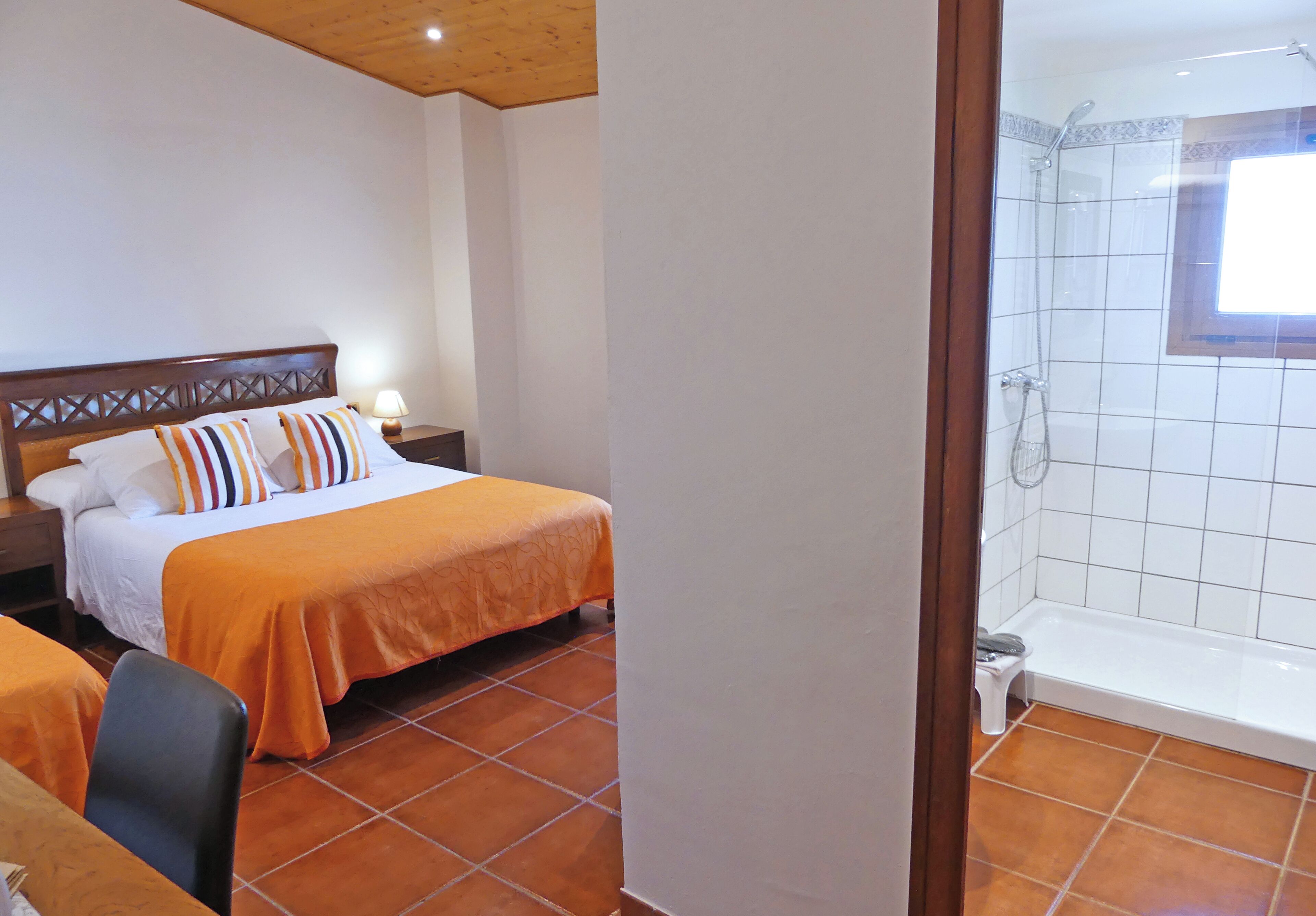 Ein Hotelzimmer mit Bett, Nachttisch, Stuhl, Badewanne und Fenster.