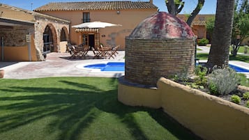 Een buitenzwembad, parasols voor strand/zwembad