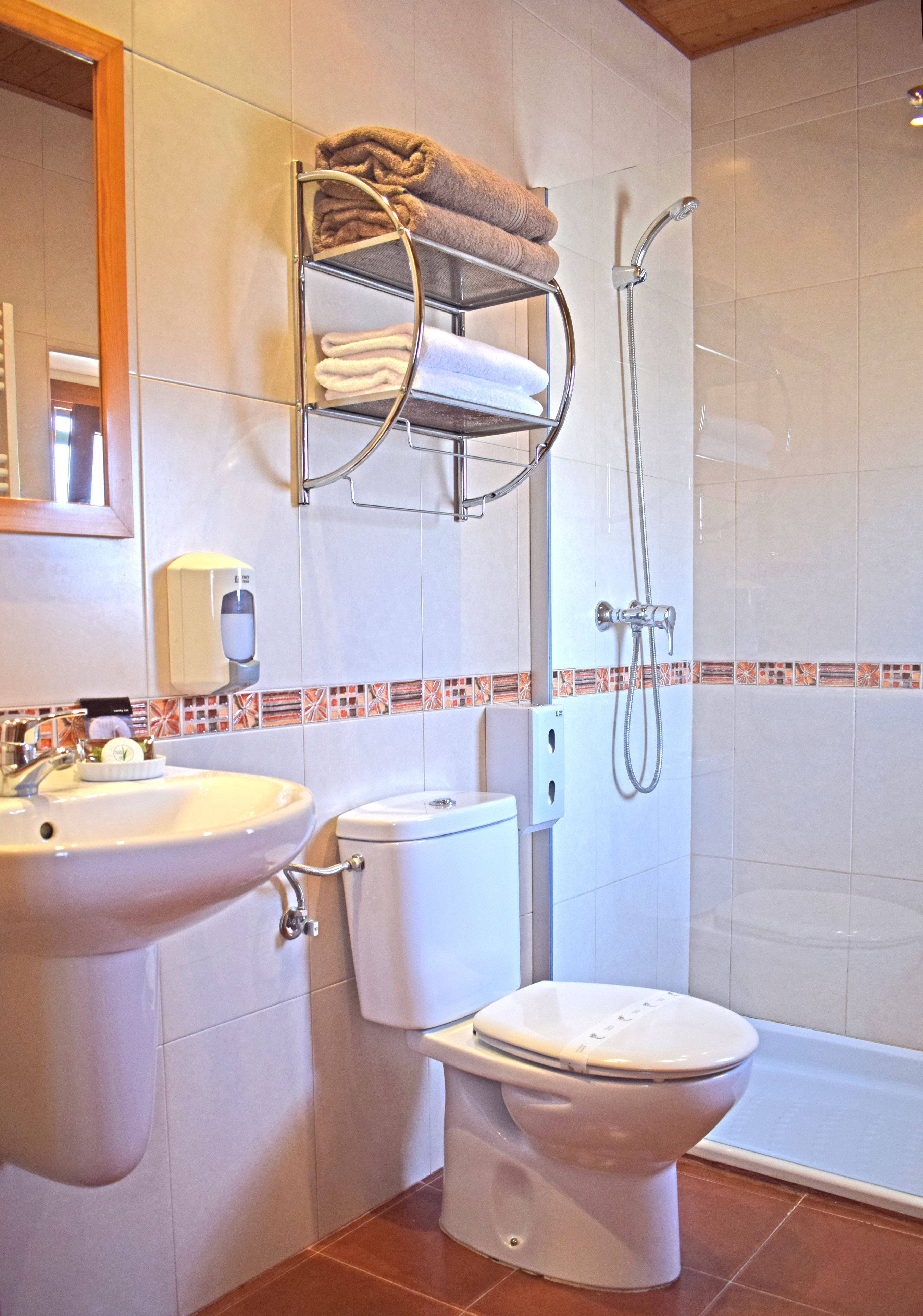 A bathroom with a sink, toilet, and shower.