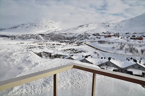 A snowy landscape with buildings and a mountain in the background. - RIBO Apartment Riksgränsen (Riksgränsen)