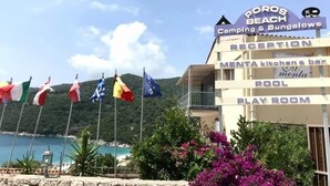 A building with a sign for 'Borros Beach Camping & Bungalows' and 'MENTA kitchen & bar'. - Poros Beach (Lefkada)