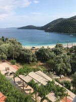 Vista costera con playa, barcos y un paisaje montañoso.