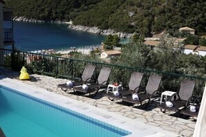 Una piscina al aire libre de temporada, sombrillas