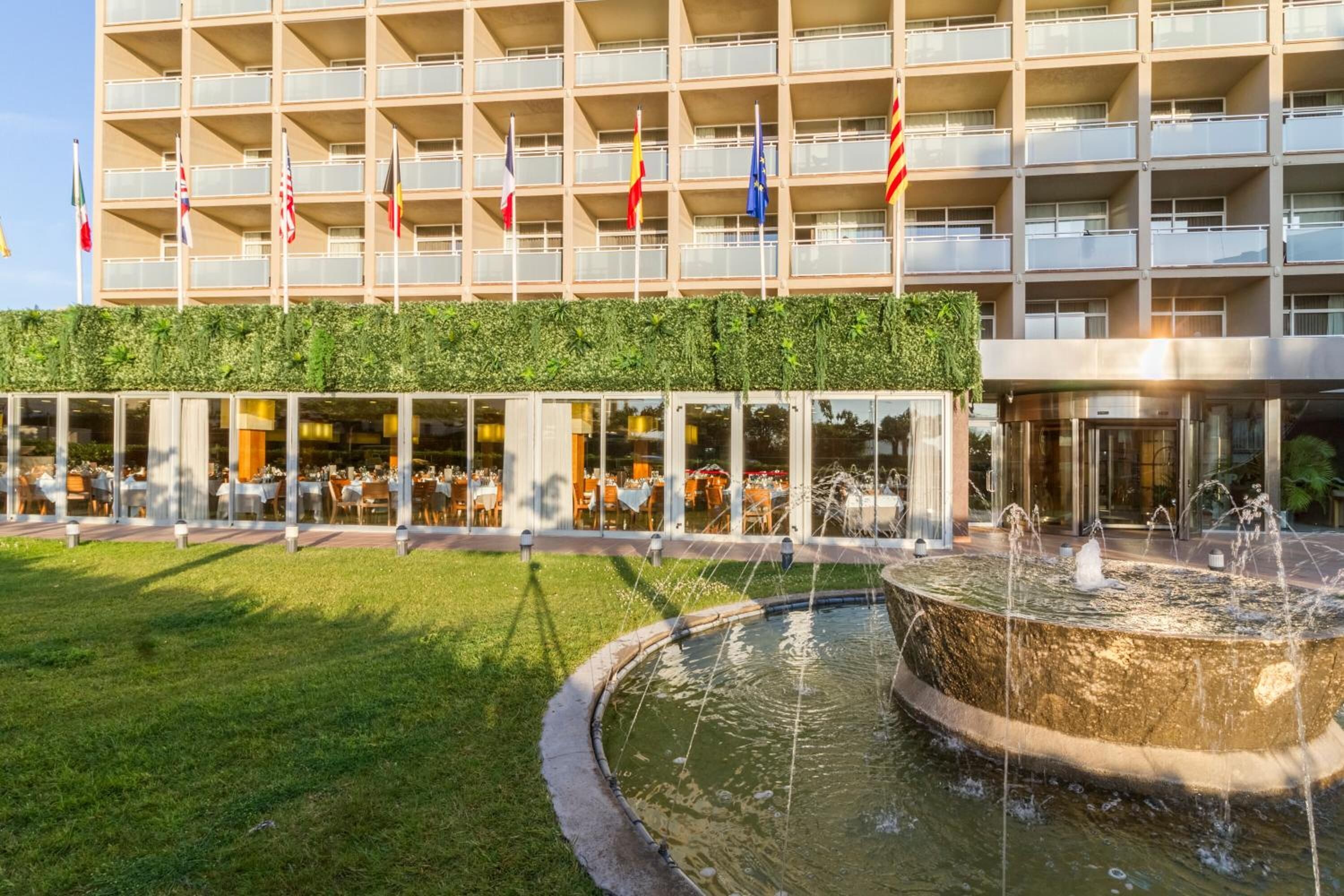 Un hôtel au design moderne, doté d’un jardin sur le toit, d’un espace de restauration avec des places assises en plein air et d’un élément décoratif central composé d’une fontaine ou d’un bassin.