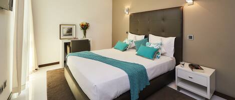 A modern bedroom with a large bed, bedside tables, a nightstand, and a wall-mounted TV.