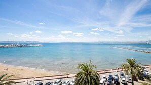 A coastal view with a beach, parked cars, and a clear sky. - Hotel Risech (Roses)