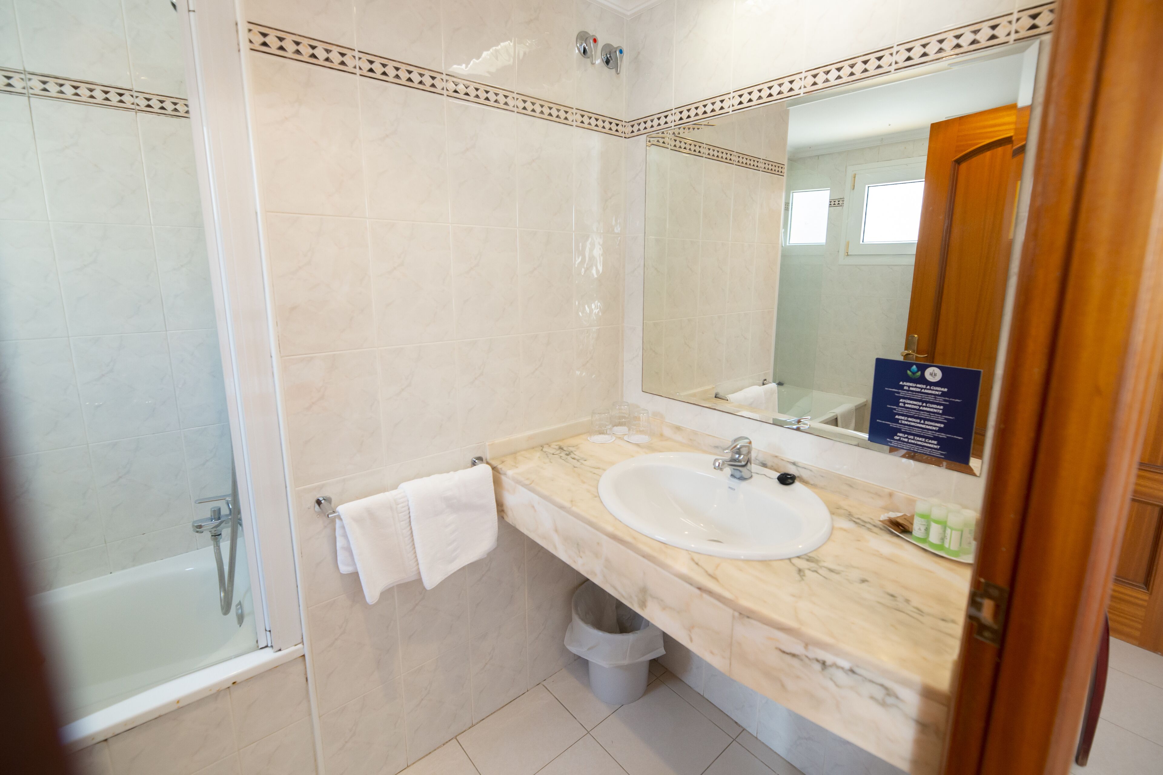 A bathroom with a marble sink, a large mirror, and a shower.