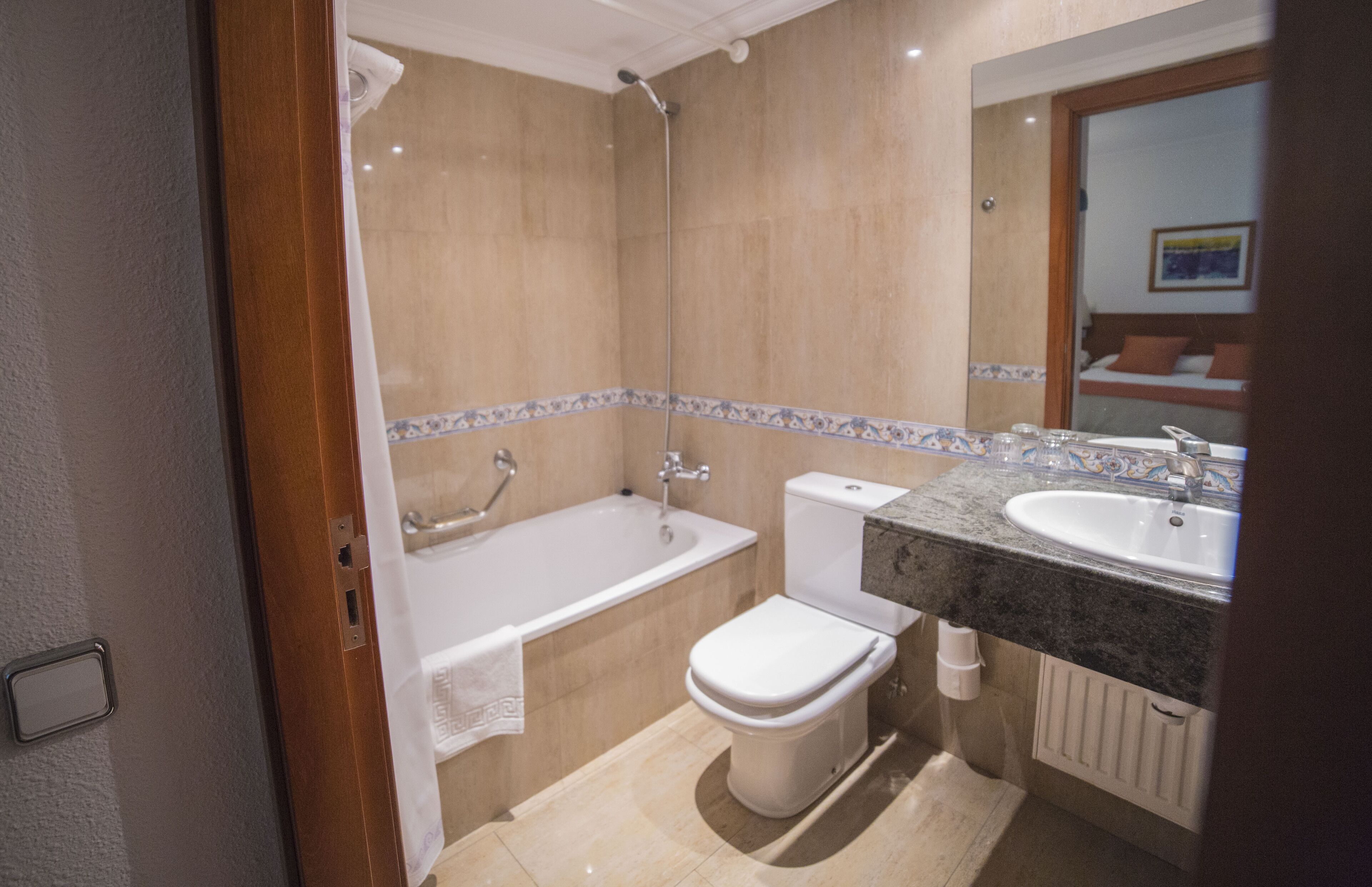 A bathroom with a bathtub, toilet, and sink.