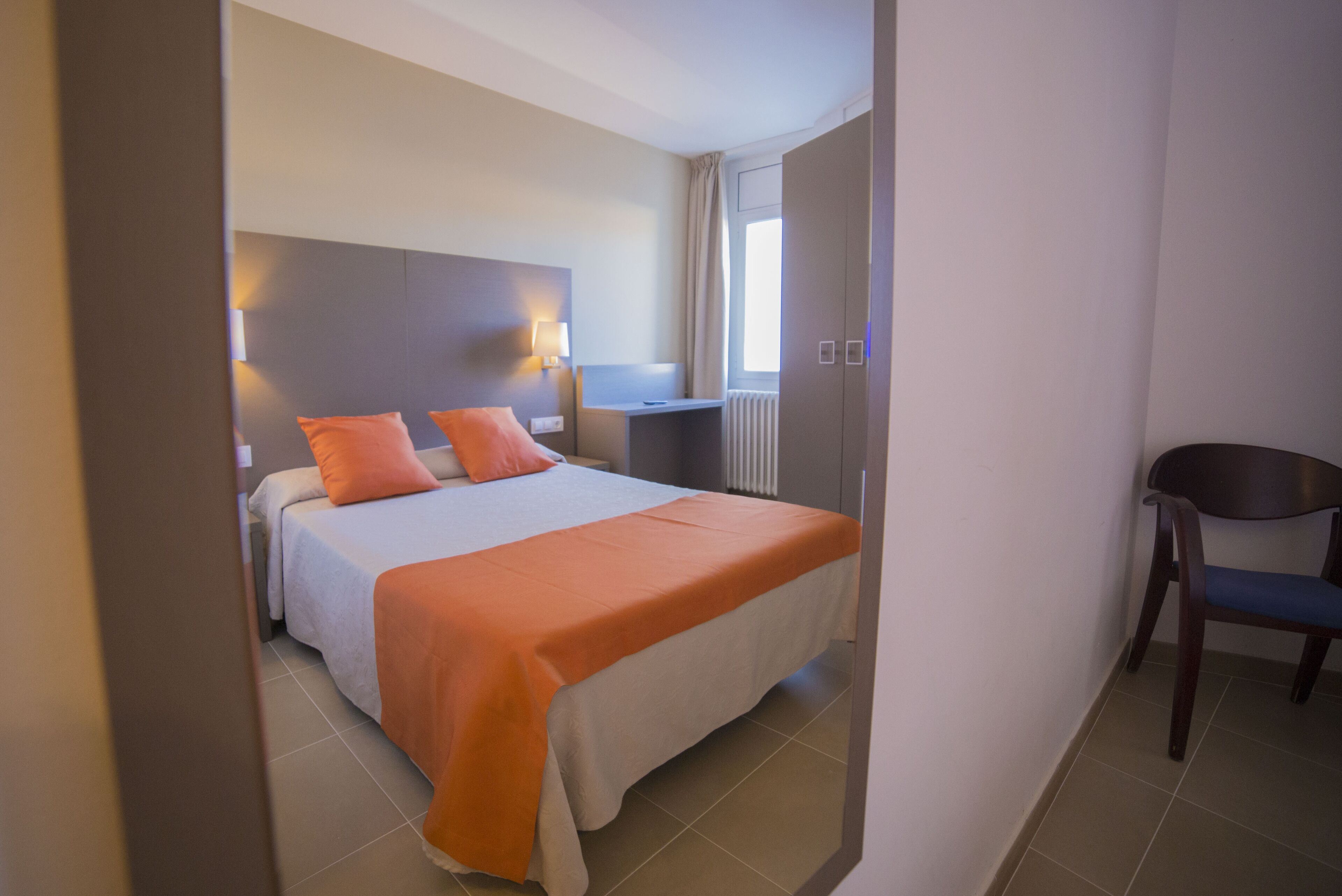 Ein Hotelzimmer mit einem Bett, einem Schreibtisch und einem Stuhl.