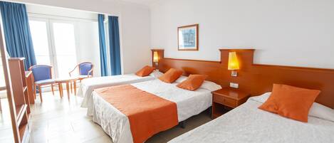 Une chambre d’hôtel avec deux lits, un bureau, des chaises et une fenêtre avec des rideaux.