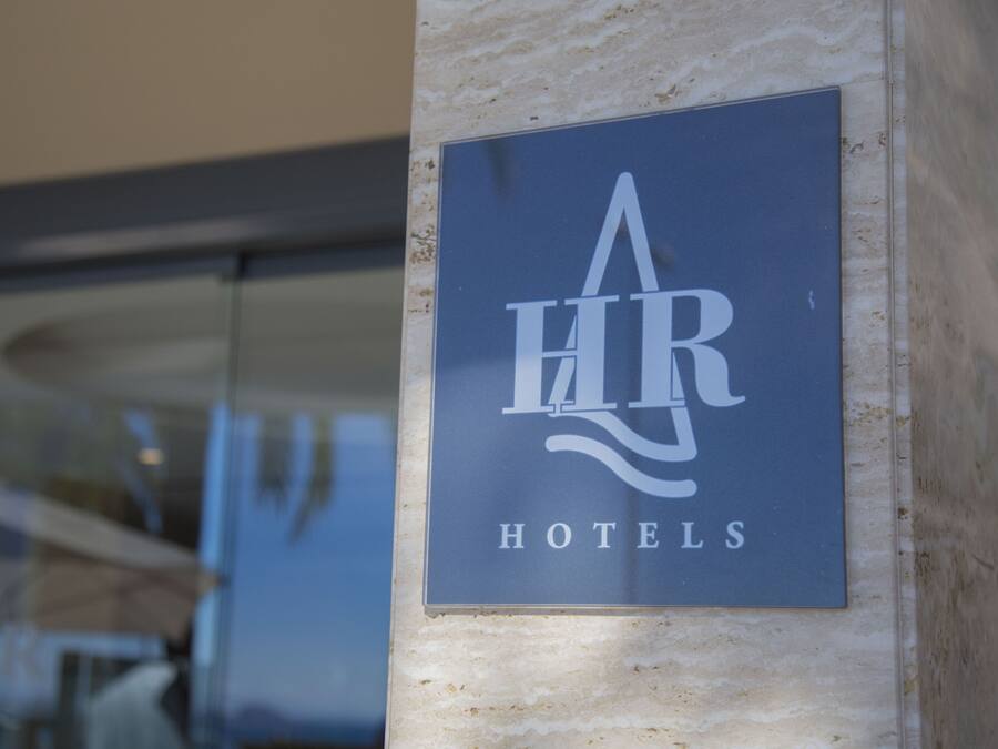 Un cartel de 'HR Hotels' sobre una pared de mármol.