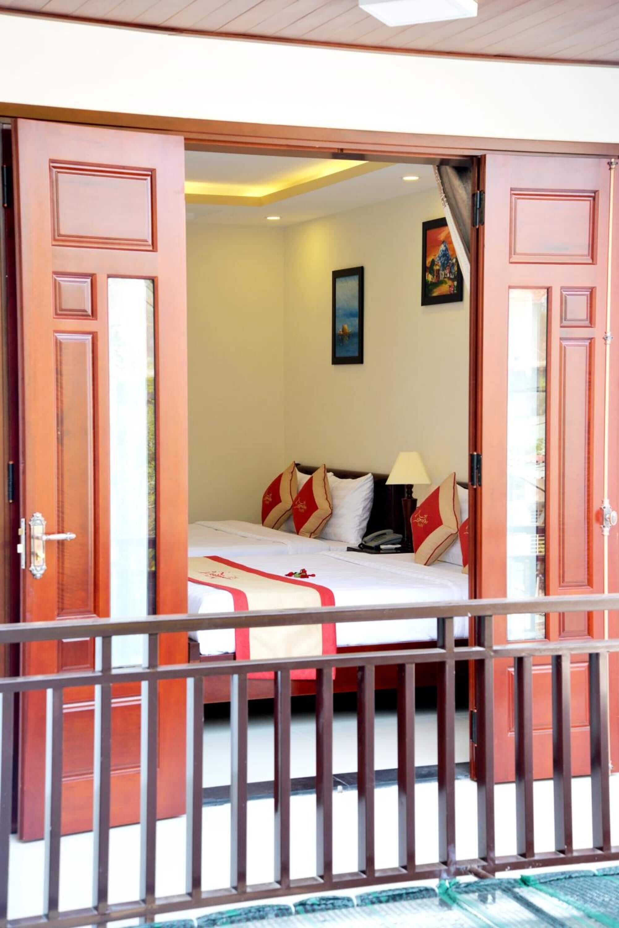 A hotel room with a bed, a nightstand, a lamp, and a painting on the wall.