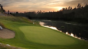 A golf course with a water hazard, a flagstick, and a flag. - Hotell Kringelstaden (Sodertalje)