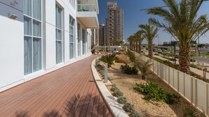 Un edificio moderno con amplios ventanales y una terraza de madera.