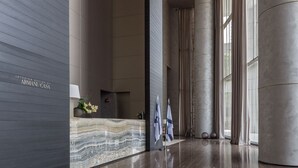 A modern lobby with a marble reception desk, large windows, and a polished wood floor. - White City Tower (Tel Aviv)