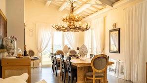 Un espace repas comprenant une table en bois, des chaises et un lustre.