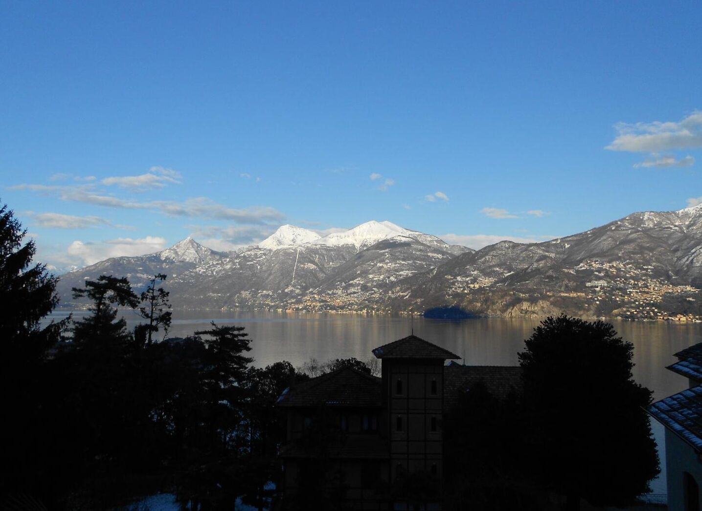 A mountain landscape with a lake and a town in the foreground.