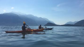 Dos kayaks en aguas tranquilas, con montañas al fondo.