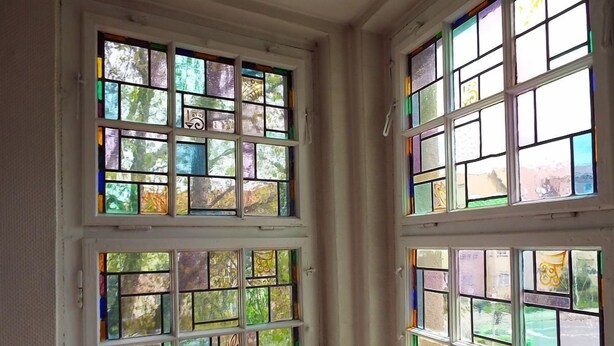 A room with a large window featuring multiple stained glass panes. - Hotel zur Tanne (Zwickau)