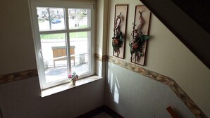 A corner room with a window, a small plant, and two wall-mounted decorations. - Hotel zur Tanne (Zwickau)