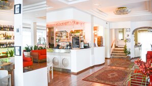A hotel lobby with a bar area, seating, and a staircase.