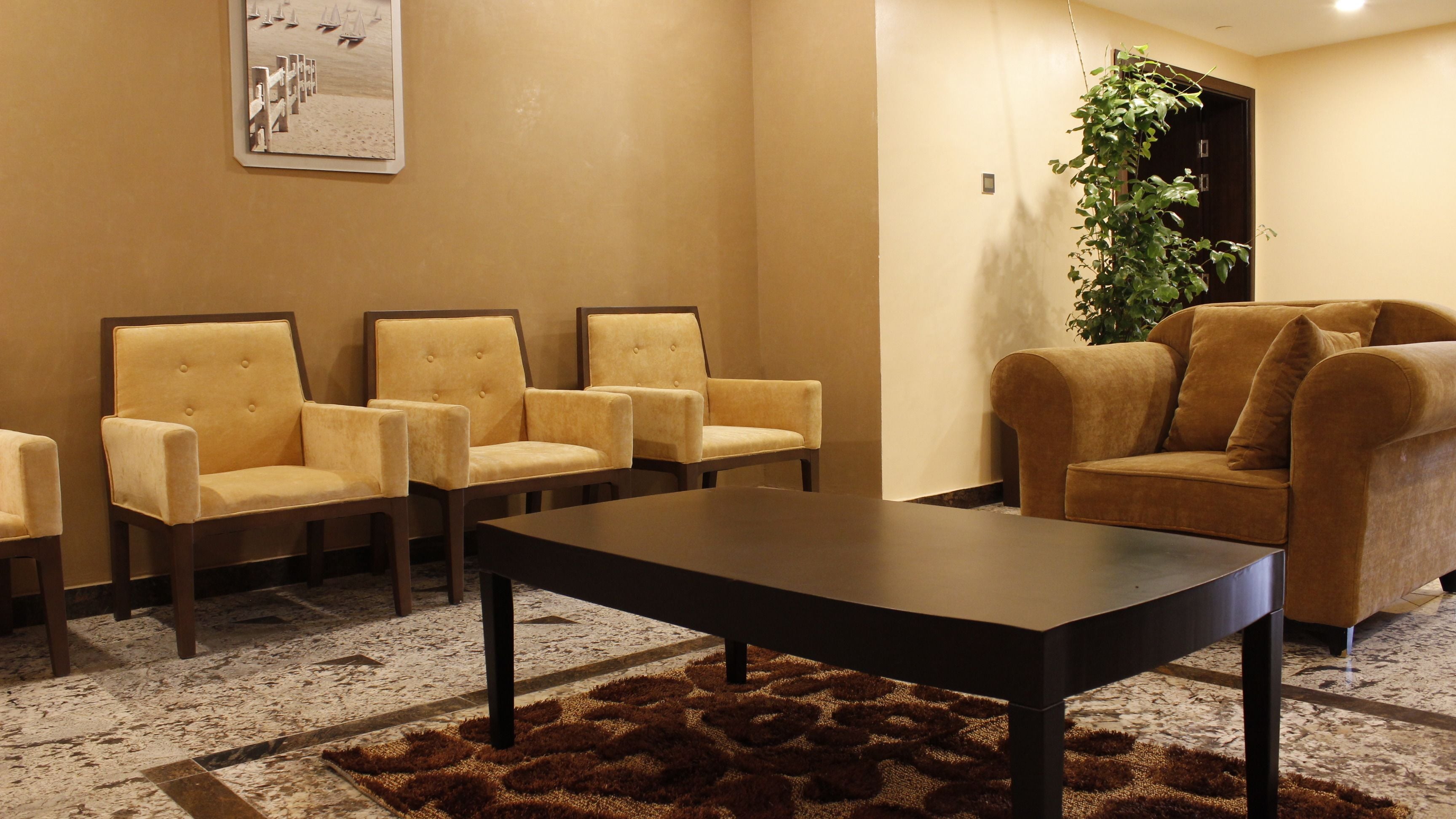 A waiting area with four armchairs, a sofa, and a coffee table.