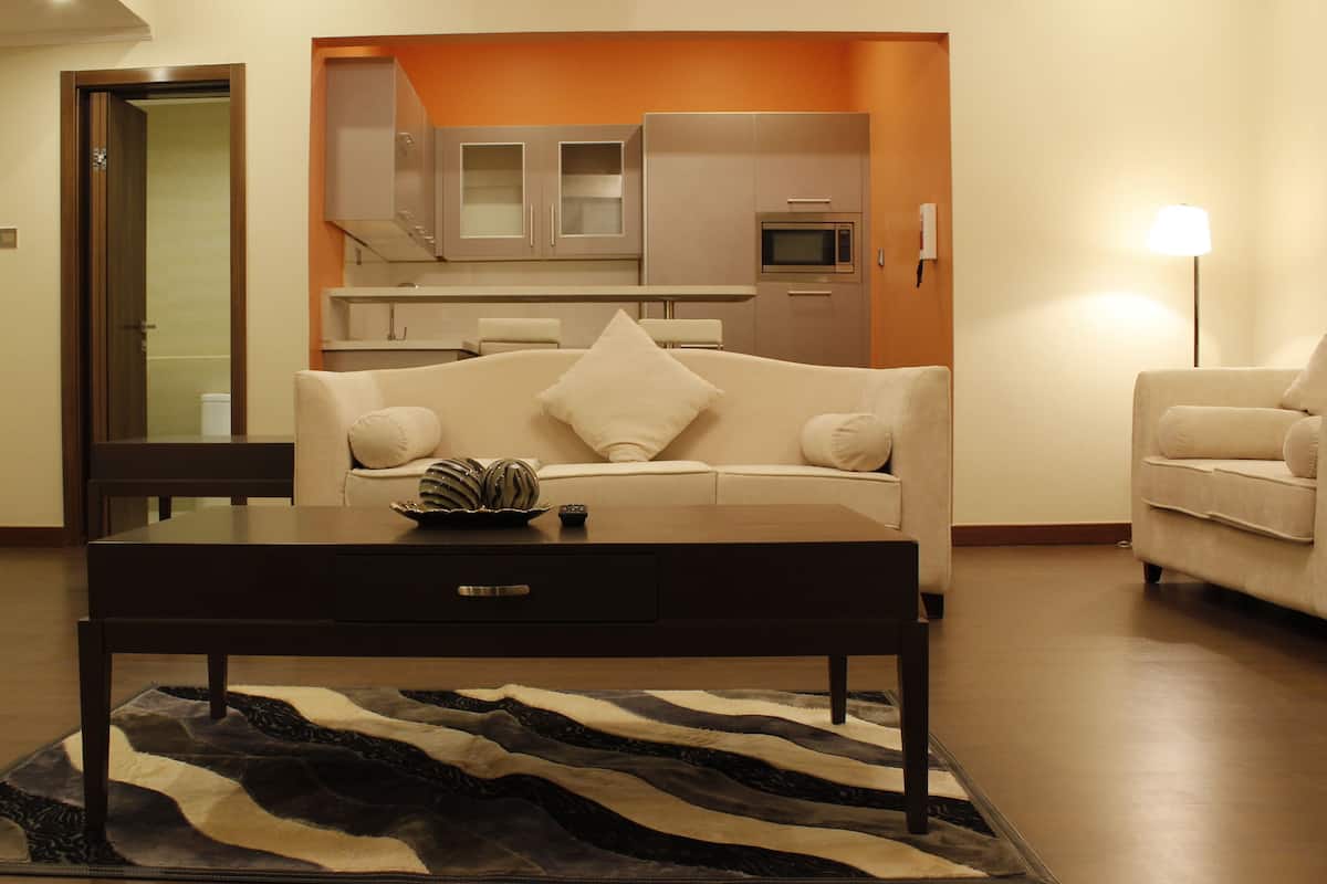 A living room with a sofa, coffee table, and a rug.