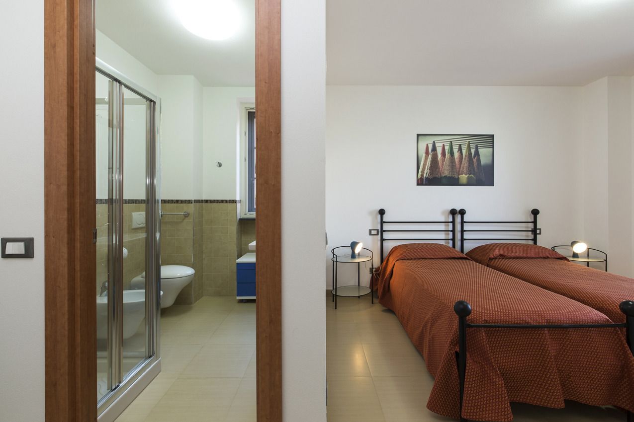 A bedroom with a bed, bedside tables, and a painting on the wall.