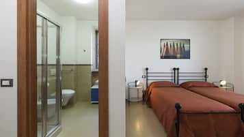 A bedroom with a bed, bedside tables, and a painting on the wall.