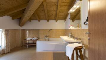 A modern bathroom with a bathtub, a sink, and a mirror.