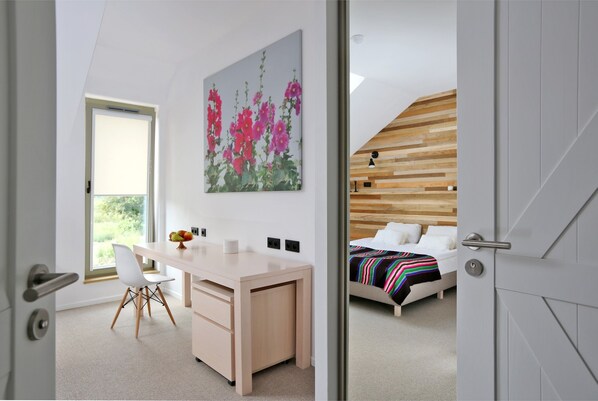 Une chambre à coucher moderne, avec un lit, un bureau et une grande fenêtre.