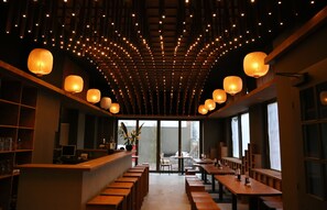 A restaurant with a long counter, wooden benches, and hanging lanterns. - Hotel de Saxe (Leipzig)