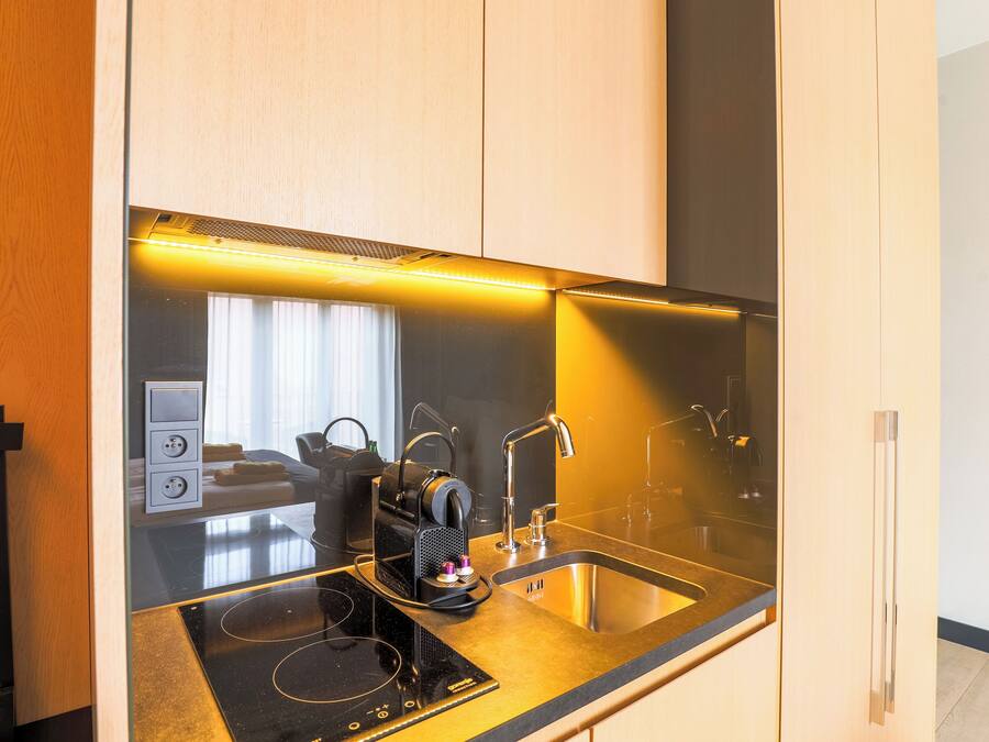 Eine moderne Küche mit Einbauherd, Spüle und Kaffeemaschine.