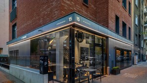 Un bâtiment moderne doté d’une façade vitrée et d’un espace extérieur aménagé pour accueillir des clients.