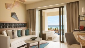 Camera d'albergo moderna con divano, tavolino da caffè e vista sul mare.