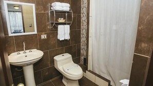 A bathroom with a sink, toilet, and a towel rack with folded towels.