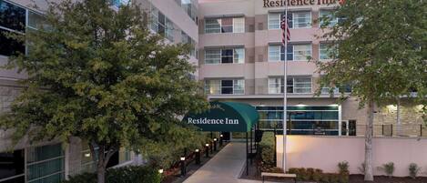 A multi-story building with a 'Residence Inn' sign, a flag, and a covered walkway.