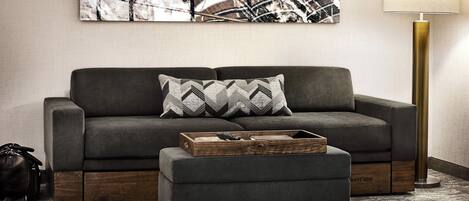 A modern living room with a sofa, a coffee table, and a floor lamp.