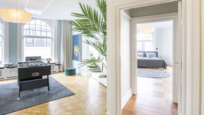 Um quarto espaçoso com mesa de pebolim, uma janela grande e uma planta.
